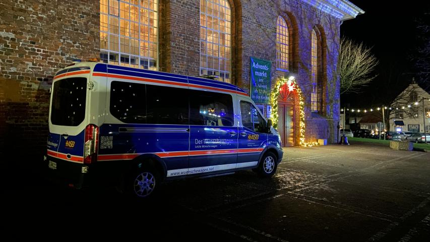 Der Wünschewagen vor der hell erleuchteten Kirche Der Wünschewagen vor der hell erleuchteten Kirche